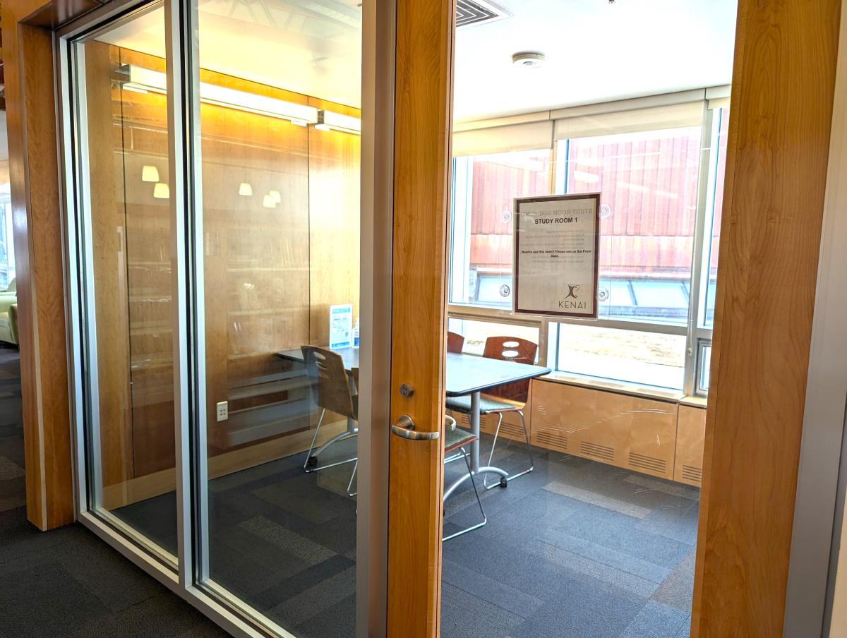 Image of Study Room 1. Table and chairs are visible through glass wall.